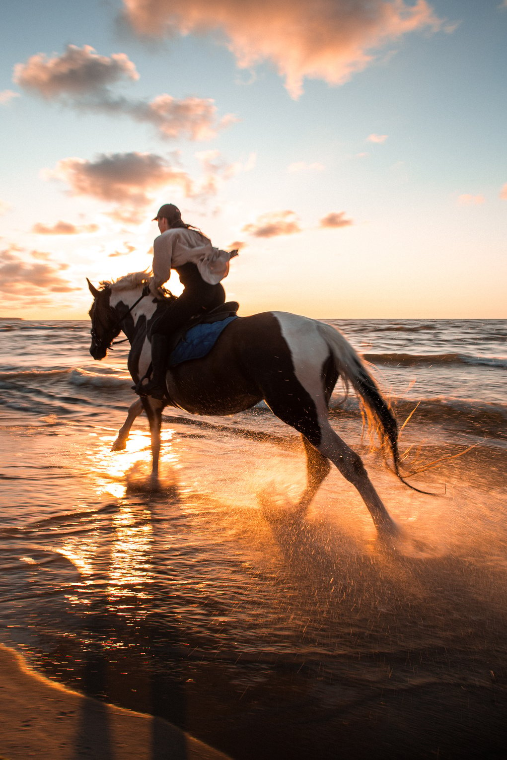 A Woman Horseback Riding by a Sea